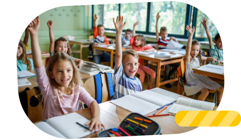 Group of elementary school children raising their hands in the classroom.